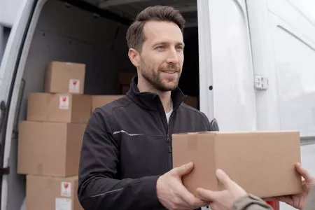 Ein Transportmitarbeiter übergibt Pakete